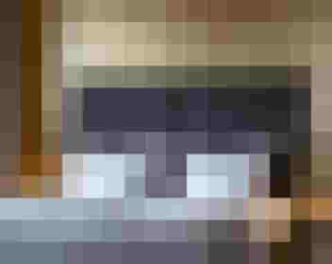 Modernes Doppelbett mit grauem Kopfteil und weißen Kissen im Luxushotel Salzburg Wellnesshotel