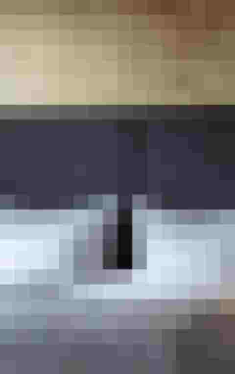 Modernes Doppelbett mit grauem Kopfteil und weißen Kissen im Luxushotel Salzburg Wellnesshotel