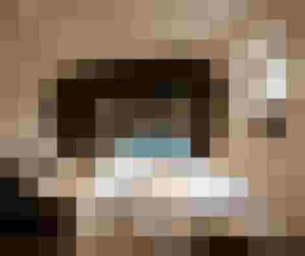 Modernes Wellnesshotel-Zimmer mit Holzdesign, Doppelbett, Fenster und blauen Kissen