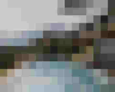 Panoramic view of DAS.GOLDBERG wellness hotel with infinity pool and Alpine landscape in Salzburger Land